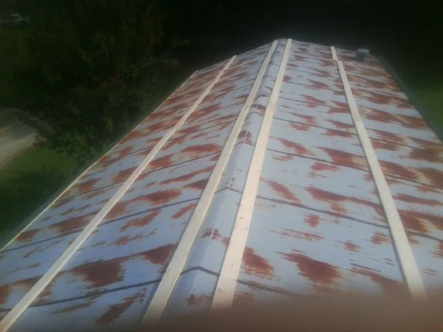 Rusted metal roof panels with new wood purlins before replacement — Storm Damage Roof Repair in Bonfield by Roofing Brothers