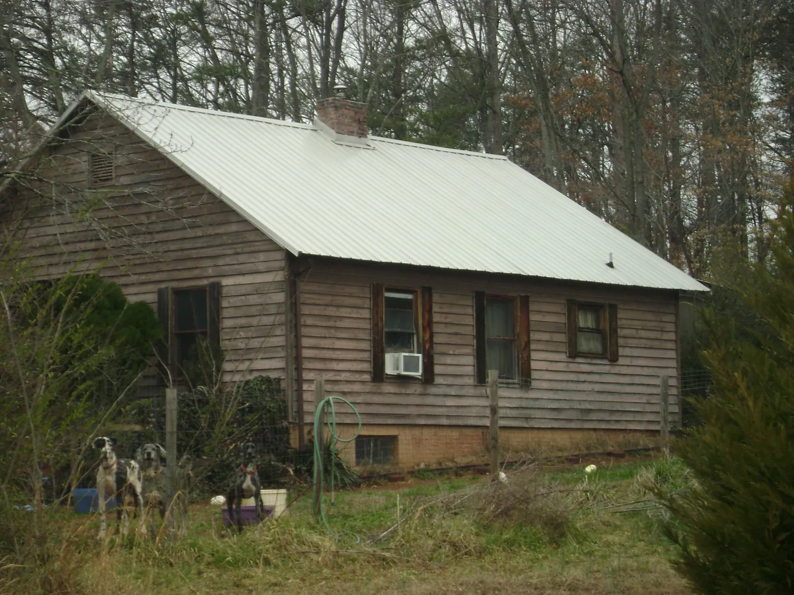 White metal roof on an old wood sided farmhouse, from a Metal Roof Installation job in Bonfield